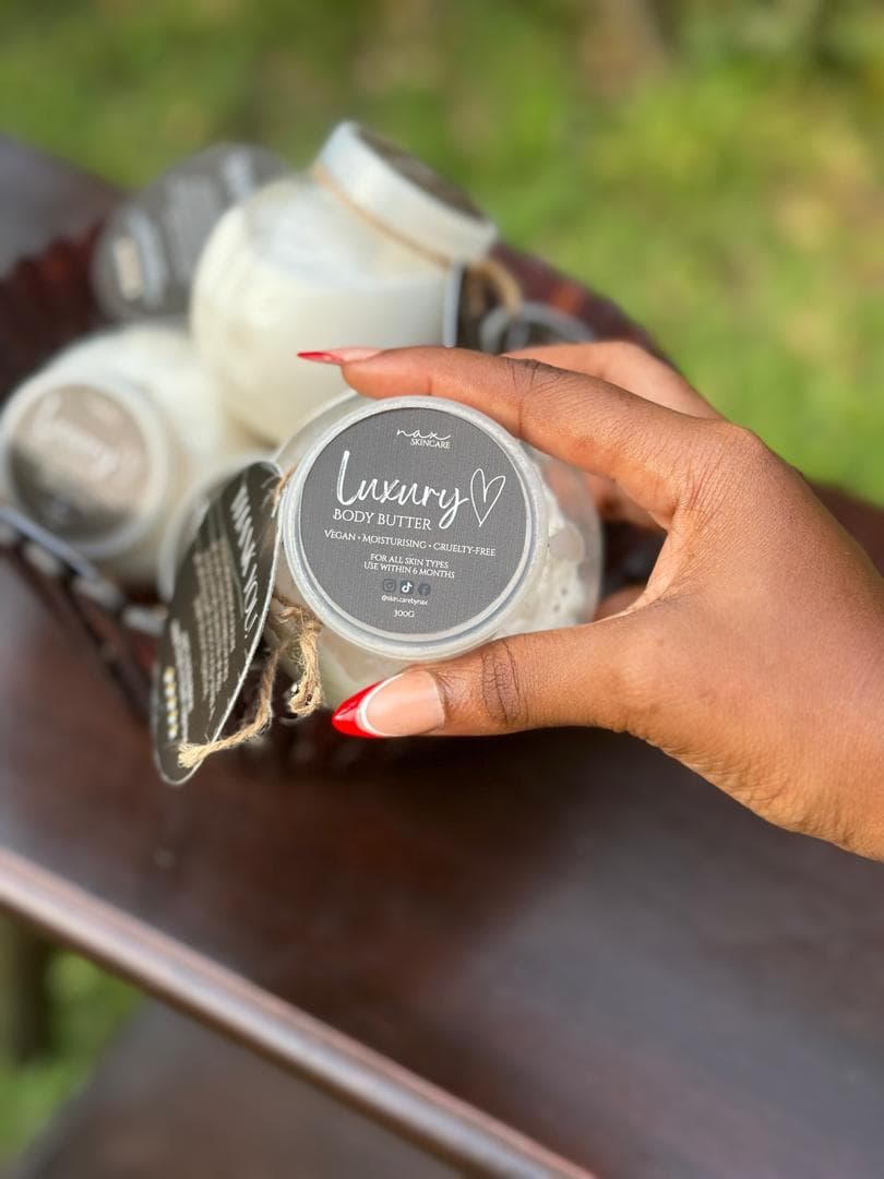 NAX Luxury Body Butter, lid label showing, held in the hand